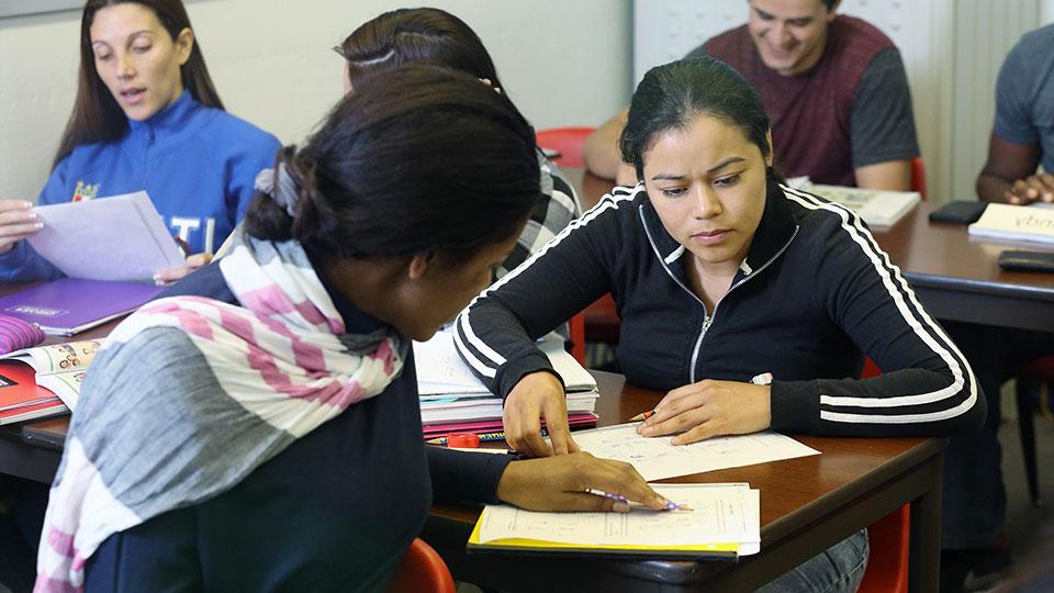 非母语英语课程 students working with an instructor in a classroom